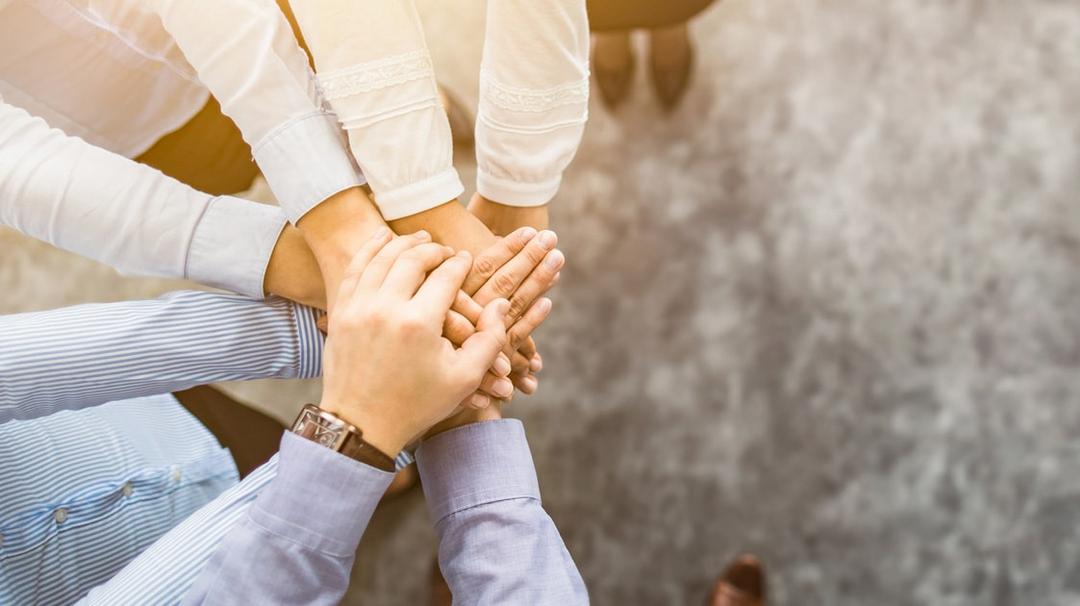 Group of business people with their hands stacked on top of each other